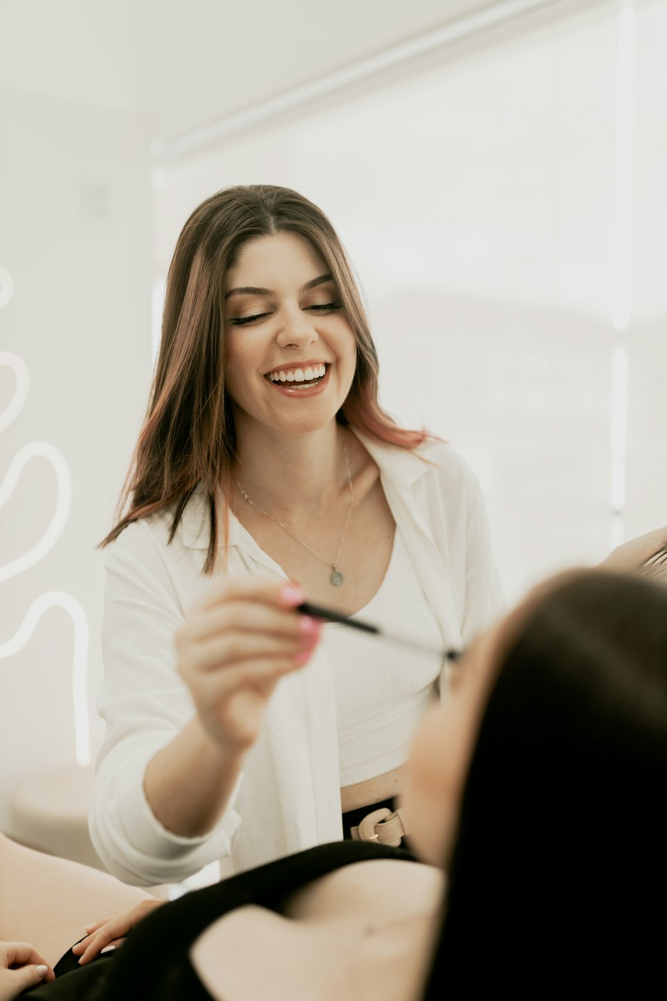 Beautician applies mascara to a customer in a salon.